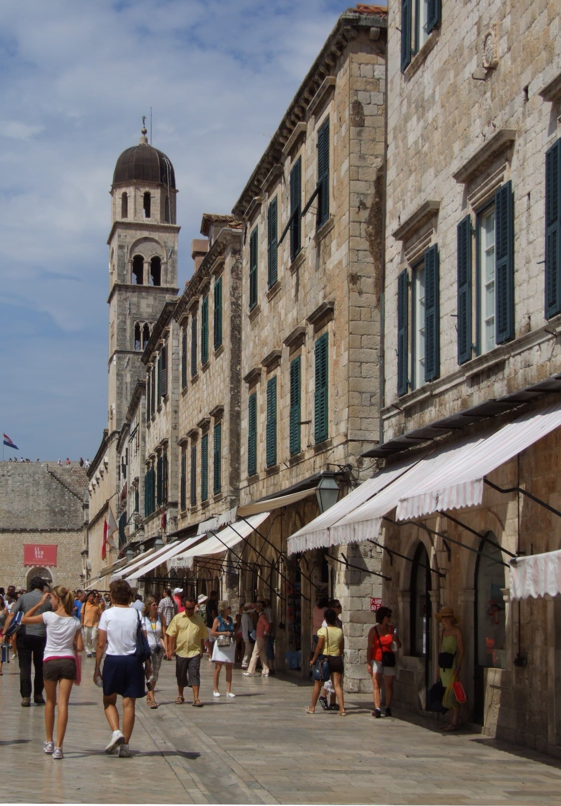 Stradun main street inside Dubrovnik Old Town with stone buildings and outdoor tables